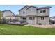 Beautiful backyard featuring a wooden patio set, manicured grass, and outdoor seating at 1641 Cedarwood Dr, Longmont, CO 80504