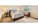 Comfortable bedroom with a dresser, side table, and a window bringing in natural light at 1641 Cedarwood Dr, Longmont, CO 80504