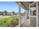 Inviting covered front porch with white railing overlooking the landscaped front yard and quiet street at 1641 Cedarwood Dr, Longmont, CO 80504
