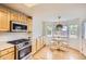 Bright kitchen area with stainless steel appliances, bay windows, and a dining table at 1641 Cedarwood Dr, Longmont, CO 80504