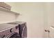 Practical laundry room with modern side-by-side washer and dryer at 1641 Cedarwood Dr, Longmont, CO 80504