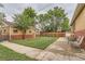 Spacious backyard with well-maintained lawn, patio area with furniture, surrounded by a wooden fence and mature trees at 1635 Winona Ct, Denver, CO 80204