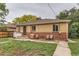Back exterior of a brick house featuring a cozy patio area with seating, a grill, and lush ground cover surrounding the space at 1635 Winona Ct, Denver, CO 80204