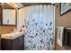 Bathroom features a neutral color scheme, single sink vanity, and decorative shower curtain at 1635 Winona Ct, Denver, CO 80204