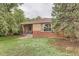 Quaint brick home with mature trees, showcasing a cozy front porch and inviting exterior at 1635 Winona Ct, Denver, CO 80204