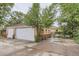 Spacious garage and driveway showcasing a basketball hoop, partially shaded by mature trees at 1635 Winona Ct, Denver, CO 80204