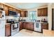 Traditional kitchen features wood cabinets, stainless steel appliances, and white tile floor at 1635 Winona Ct, Denver, CO 80204