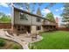 Spacious backyard with patio seating, a lush lawn, and mature trees at 7881 S Ivy Ct, Centennial, CO 80112
