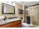 Well-lit bathroom with a granite countertop vanity, shower, and neutral decor at 7881 S Ivy Ct, Centennial, CO 80112