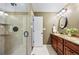 Bathroom showcasing a tiled shower with a glass door and a double granite vanity with dark wood cabinets at 7881 S Ivy Ct, Centennial, CO 80112