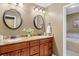 Bathroom featuring a double vanity with granite countertops and matching framed mirrors at 7881 S Ivy Ct, Centennial, CO 80112
