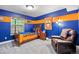 Colorful bedroom with a sports theme, a cozy bed, and a comfortable armchair at 7881 S Ivy Ct, Centennial, CO 80112