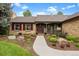 Charming single-story brick home featuring a landscaped front yard with beautiful trees and a walkway to the front door at 7881 S Ivy Ct, Centennial, CO 80112