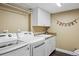 Organized laundry room featuring a washer, dryer, utility sink, and storage cabinets at 7881 S Ivy Ct, Centennial, CO 80112