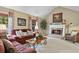Cozy living room featuring a fireplace, vaulted ceilings, and comfortable seating at 7881 S Ivy Ct, Centennial, CO 80112