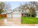 Charming two-story home featuring a three-car garage, landscaped yard, and inviting front porch at 8523 S Flower Ct, Littleton, CO 80128