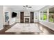 Cozy Gathering room with a fireplace, built-in bookshelves, and natural light from large windows at 8523 S Flower Ct, Littleton, CO 80128