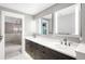 Stylish main bathroom featuring double vanity, bronze fixtures, and view into bright main bedroom at 8523 S Flower Ct, Littleton, CO 80128