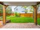 Covered brick patio overlooking a spacious backyard with a wood fence at 8523 S Flower Ct, Littleton, CO 80128