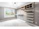 Large custom walk-in closet with plenty of shelf space, cabinets, drawers, and a window at 8523 S Flower Ct, Littleton, CO 80128