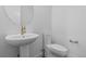 Sleek half bathroom with pedestal sink, modern fixtures, round mirror, and a low-flow toilet, designed for water conservation at 5625 W 141St Ln, Broomfield, CO 80020