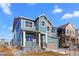 Beautiful blue two-story home with a front porch and a two-car garage showcasing curb appeal at 5625 W 141St Ln, Broomfield, CO 80020