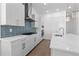 This kitchen is equipped with stainless steel appliances, modern white cabinets, and a marble countertop with a sink at 5625 W 141St Ln, Broomfield, CO 80020