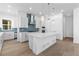 Bright, modern kitchen features white cabinetry, stainless appliances, blue tile backsplash, and a large center island with pendant lighting at 5625 W 141St Ln, Broomfield, CO 80020