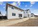 Backyard view of a two story home featuring large windows and sliding glass door at 45934 Gentry Ave, Bennett, CO 80102