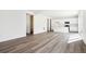 Open-concept living area seamlessly integrates vinyl floors, a white kitchen, and modern lighting at 45934 Gentry Ave, Bennett, CO 80102