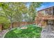 Lush backyard with a fire pit area and wooden deck with stairs, perfect for outdoor entertaining and relaxation at 13723 Milwaukee Ct, Thornton, CO 80602