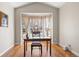 Dining room features a large window with flowing curtains and hardwood floors, providing a bright and welcoming space at 13723 Milwaukee Ct, Thornton, CO 80602