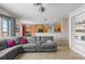 Open concept living room showcases a plush gray sectional and views into the modern kitchen at 13723 Milwaukee Ct, Thornton, CO 80602