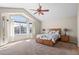 The main bedroom features large windows, a ceiling fan, and comfortable neutral carpeting at 13723 Milwaukee Ct, Thornton, CO 80602