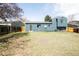 Large backyard with a blue house, wooden fence, and a mix of grass and bare spots under a clear sky at 10024 Holland Ct, Broomfield, CO 80021