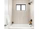 Modern bathroom featuring neutral tiles, black hardware, and a large window providing natural light above the tub at 10024 Holland Ct, Broomfield, CO 80021