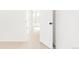 Bright hallway with neutral carpet leading to a bathroom with a white door and black hardware at 10024 Holland Ct, Broomfield, CO 80021