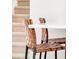 Stylish kitchen bar with leather woven chairs and staircase in the background at 10024 Holland Ct, Broomfield, CO 80021