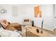 Cozy living room with a leather sofa, side chair, art and natural light at 10024 Holland Ct, Broomfield, CO 80021