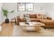 Cozy living room with brown leather sofa, area rug, stylish pillows, and bright window at 10024 Holland Ct, Broomfield, CO 80021