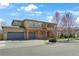 Beautiful two-story home with a three-car garage, stone accents, and a well-manicured front yard at 1204 S Balsam Ct, Lakewood, CO 80232
