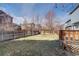 Fenced backyard offers privacy with mature trees, lawn, and a deck, perfect for outdoor gatherings at 1188 Mulberry Ln, Highlands Ranch, CO 80129