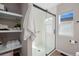 Bright bathroom featuring a sliding glass door shower, white towels, and shelves at 1188 Mulberry Ln, Highlands Ranch, CO 80129