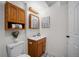 Charming bathroom features wood cabinets, a vanity, and a decorative mirror with overhead lighting at 1188 Mulberry Ln, Highlands Ranch, CO 80129