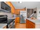 Bright kitchen with wood cabinets, stainless steel appliances, and an island with room for cooking and entertaining at 1188 Mulberry Ln, Highlands Ranch, CO 80129