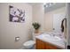 Charming powder room featuring a pedestal sink, floral art, and toilet at 1188 Mulberry Ln, Highlands Ranch, CO 80129
