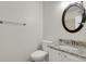 Bright bathroom with granite vanity, brushed nickel faucet and round mirror at 200 Whitehaven Cir, Highlands Ranch, CO 80129