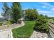 Beautifully landscaped backyard with green grass, rock borders, and mature trees at 12671 Home Farm Ln, Westminster, CO 80234