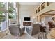 Open-concept living area with a fireplace, large windows, a TV, and a seamless flow to the dining area at 12671 Home Farm Ln, Westminster, CO 80234