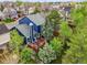 Aerial view of a blue two-story home with a back deck and fenced yard surrounded by lush trees at 7927 Elmwood St, Littleton, CO 80125